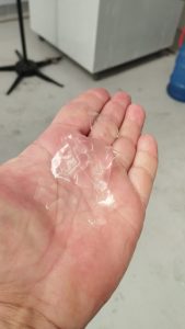 A imagem mostra a mão de uma pessoa caucasiana que segura uma porção de gelo em escama.